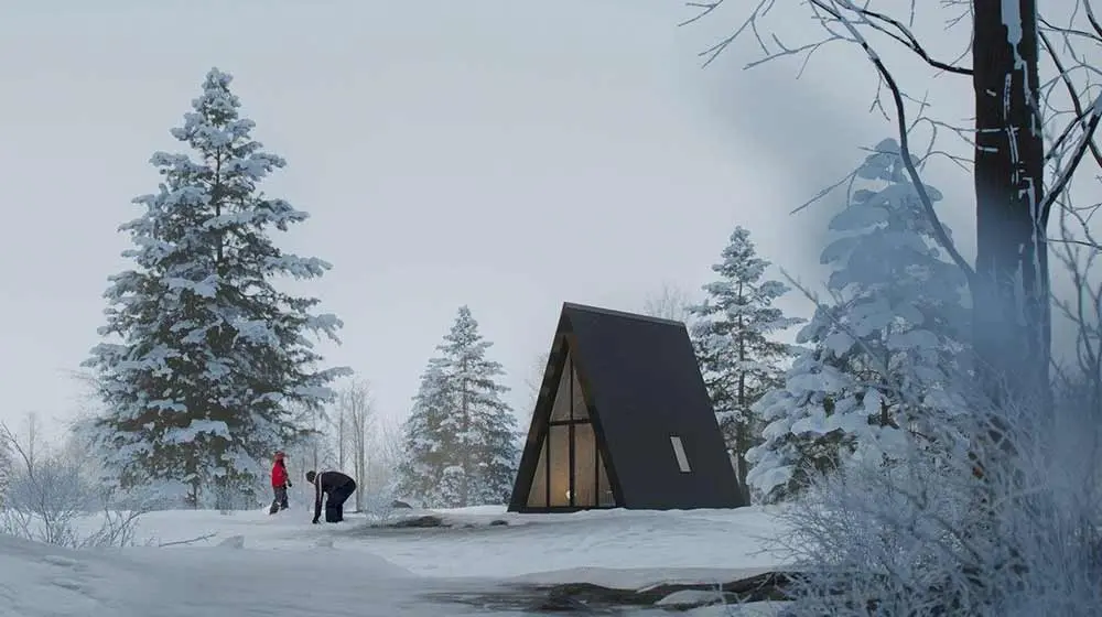 Modern dark A-frame cabin in winter snow environment